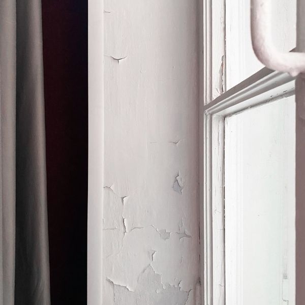 Interior wall with peeling paint inside a Pretoria home.